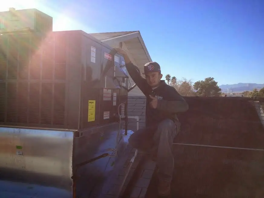 HVAC technician performing AC Tune-Up on a rooftop unit in Radford